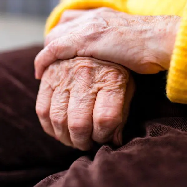 Deux mains âgées l'une sur l'autre.