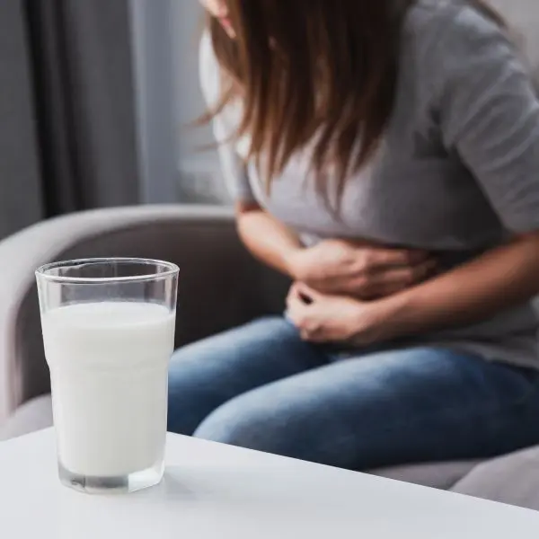 Une femme se tient l'abdomen sous la douleur.
