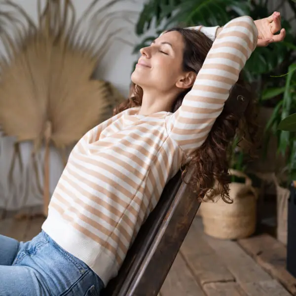 Une jeune femme se prélasse sur une chaise.