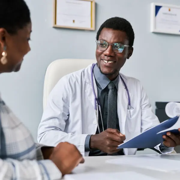 Un docteur souriant s'adresse à sa patiente.