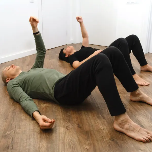 Un couple allongé sur le sol pratique des exercices pour fluidifier le sang naturellement.