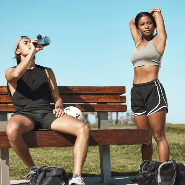 Un couple de sportifs s'étirent et récupèrent après l'effort.