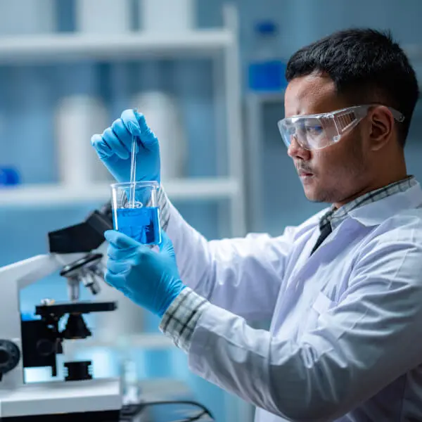 Un scientifique en laboratoire observe une éprouvette pour détemriner un lien entre klamath et cellule souche.