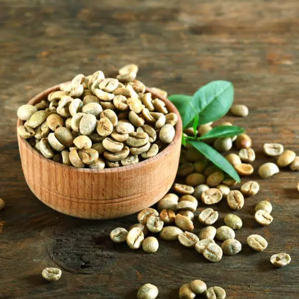 Un bol débordant de grains de café verts.