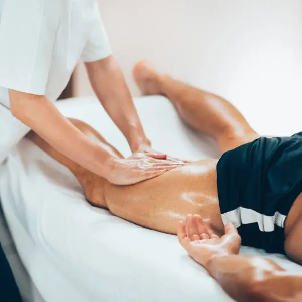 Massage thérapeutique des muscles de la jambe pour favoriser la récupération musculaire.