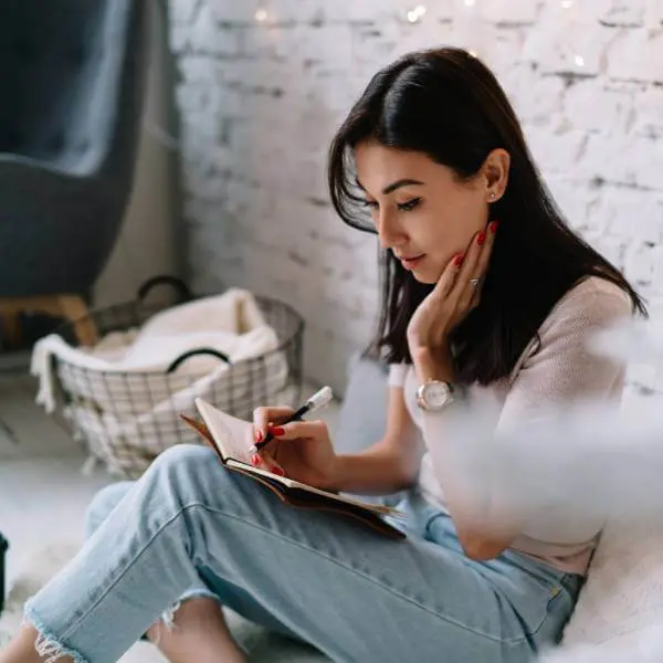Une jeune femme tiens un journal de ses symptômes d'intoxication aux métaux lourds.
