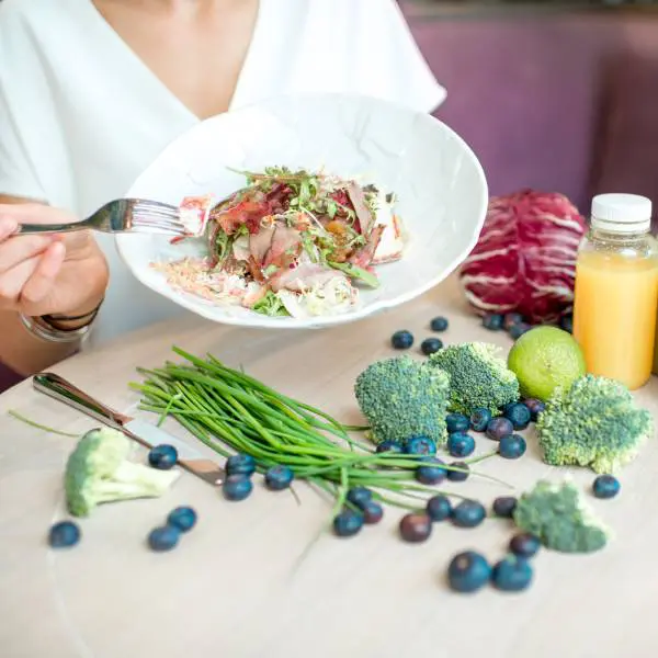 Une assiette pleine de légumes sur une table riche en aliments sains pour nettoyer le foie naturellement.