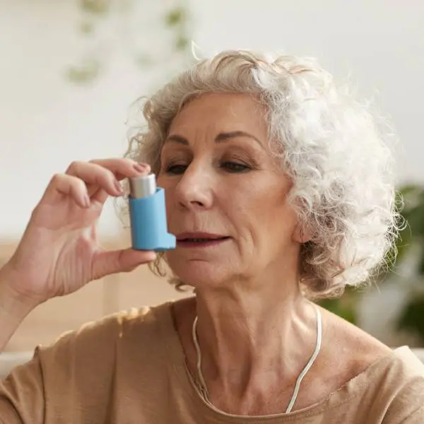 Une dame âgée avec un inhalateur pour l'asthme.