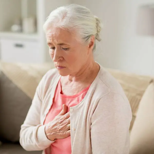 Une dame essouflée se tient la poitrine.