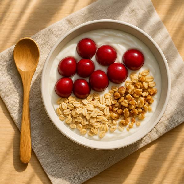 Bol de petit‑déjeuner garni de cerises fraîches, flocons d’avoine et noix