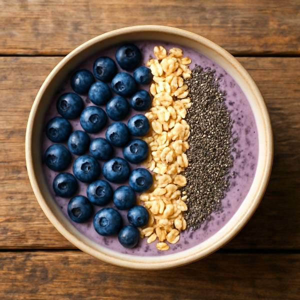Vue du dessus d’un smoothie bowl garni de myrtilles et de graines